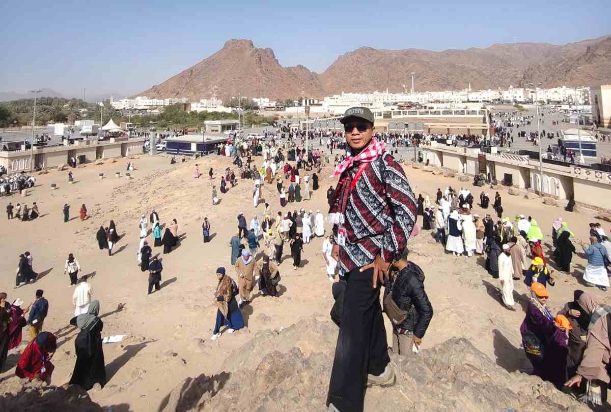 Penulis berdiri di puncak bukit Rumat (Pemanah), nampak terlihat para penziarah lalu lalang dan Jabal Uhud yang kokoh berdiri dengan warna merah kecoklatan (foto : Adre Marsetio)