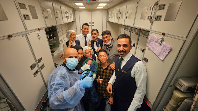 Febrian Rahmatulloh (tengah baju kotak-kotak) usai membantu persalinan di kabin pesawat. (ist)