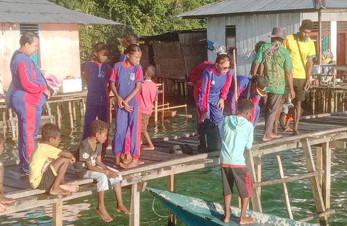 Anak-anak Papua harus nemembus ombak untuk mengikuti TKA di Serui. (ist)