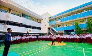 Kepala sekolah SD Muhammadiyah 6 Gadung Surabaya, Munahar, memimpin apel pagi. (ist)