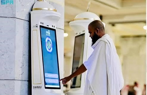 Seorang jemaah haji mencoba akses informasi dari robot di tanah suci. (ist)