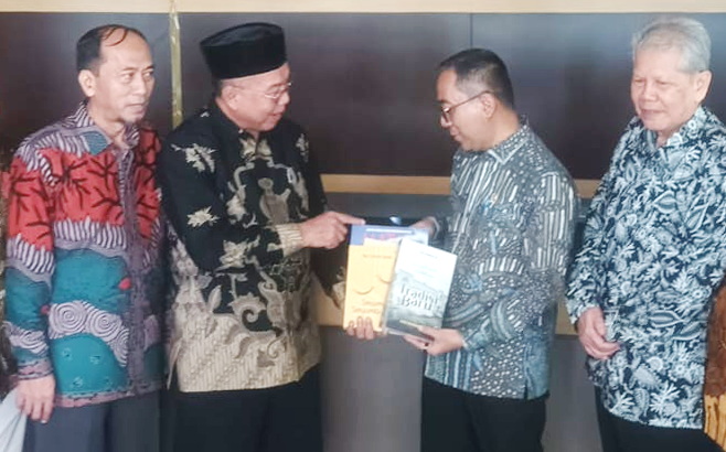 Ketua PWM Jatim, Sukadiono (batik hitam) memberikan beberapa buku pada Mendiktisaintek, Prof. Brian Yuliarto. (nun)