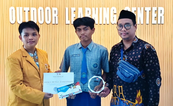 Rizky Putra Ramadhan menerima piagam penghargaan dan hadiah didampingi Ayub Nurcholiq (kanan).