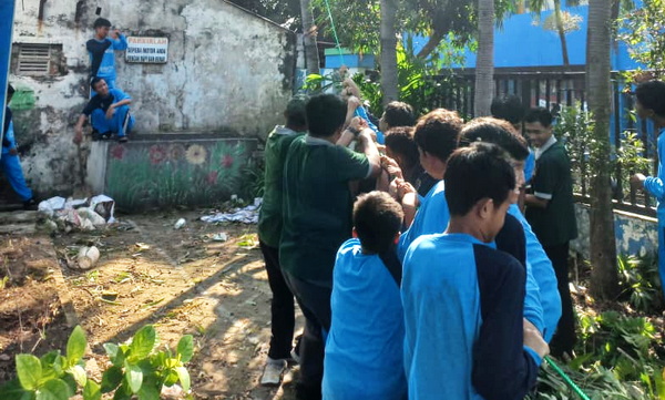 Para guru dan siswa bersama membersihkan lokasi yang akan disulap menjadi Laboratorium Alam SMP Muhammadiyah 17 Surabaya. (ist)