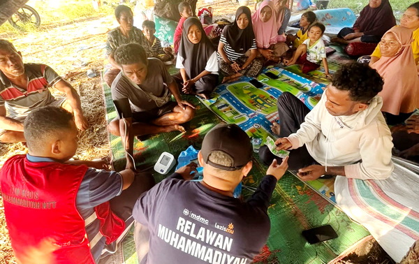 Tim relawan Muhammadiyah dan tim medis melakukan pemeriksaan kesehatan penyintas gempa NTT di tenda pengungsian. (mdmc)
