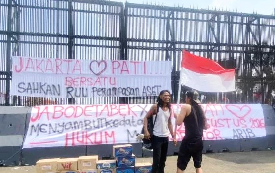 Kelompok aksi memasang spanduk di depan gedung DPR/MPR Jakarta. (ist)